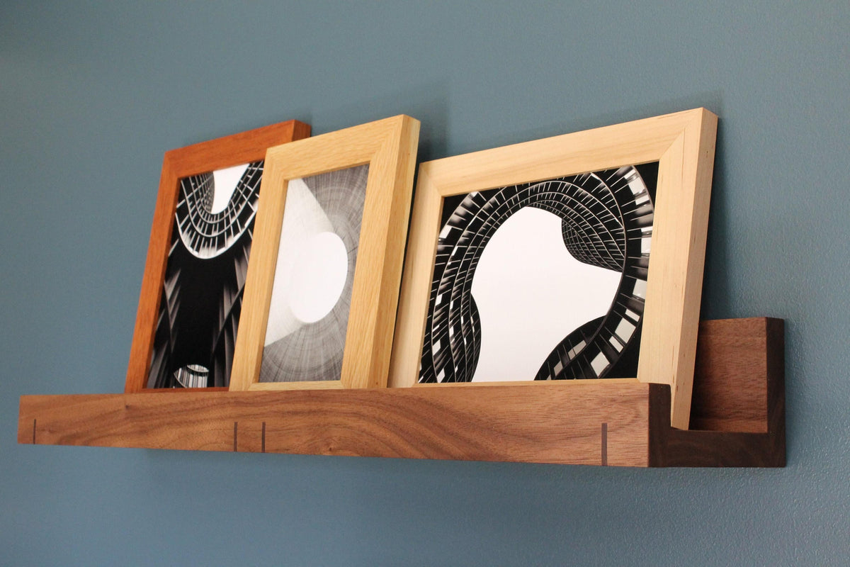 Walnut 3-inch ledge shelf holding three framed black and white architecture prints