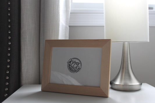 Maple 5 x 7 desktop frame on a nightstand beside a silver table lamp