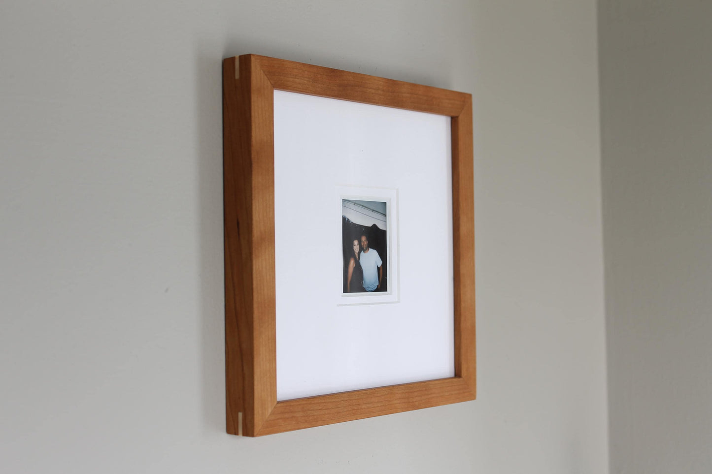 a picture hanging on a wall with a wooden frame