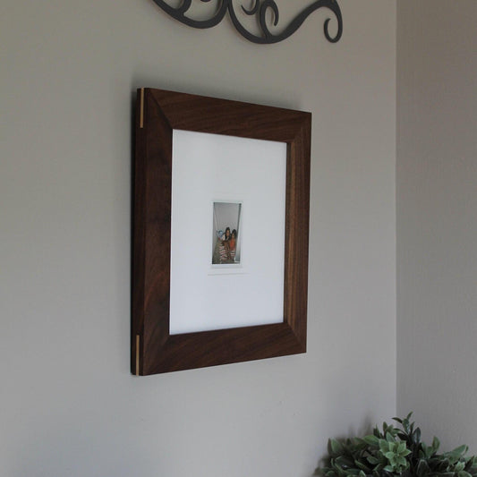 Walnut modern frame holding an Instax Mini photo