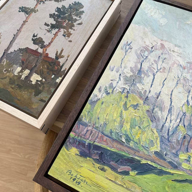 Two oil landscape paintings in walnut and maple floating canvas frames