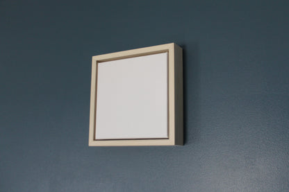 a white picture frame hanging on a blue wall