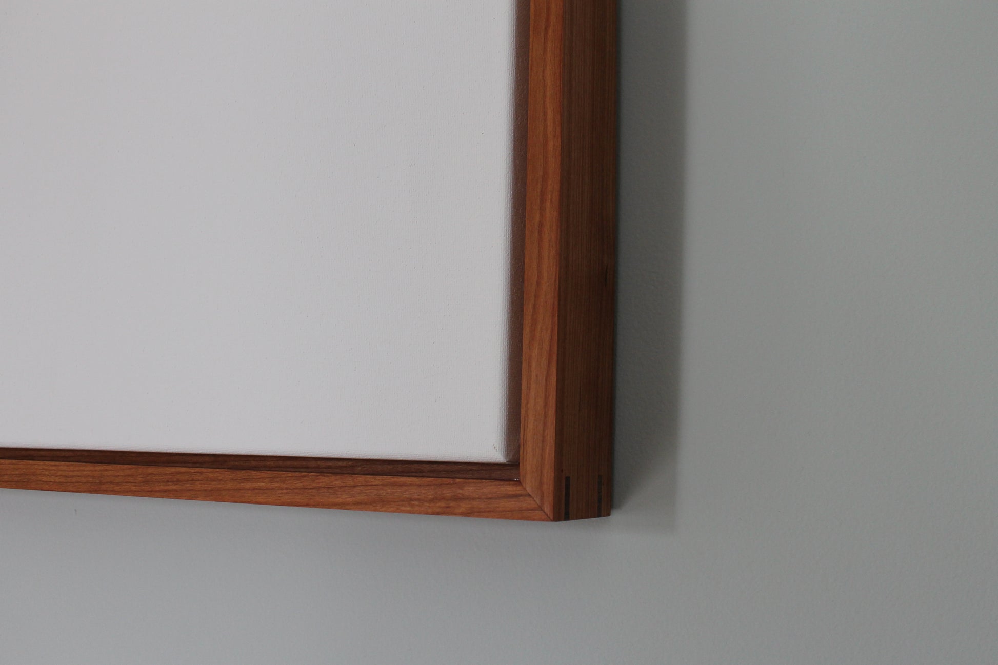 a mirror mounted on a wall with a wooden frame