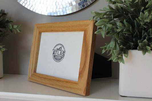 White oak 4 x 6 desktop frame shown at an angle on a shelf next to a white planter