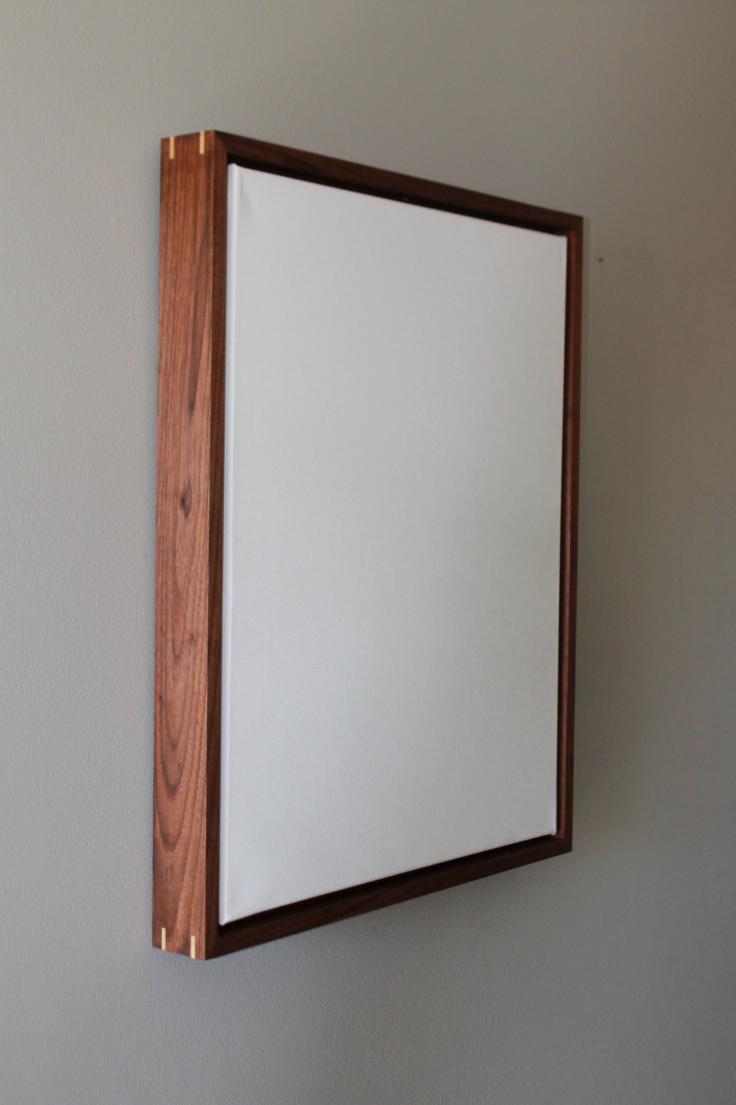 a white refrigerator with a wooden handle hanging on a wall