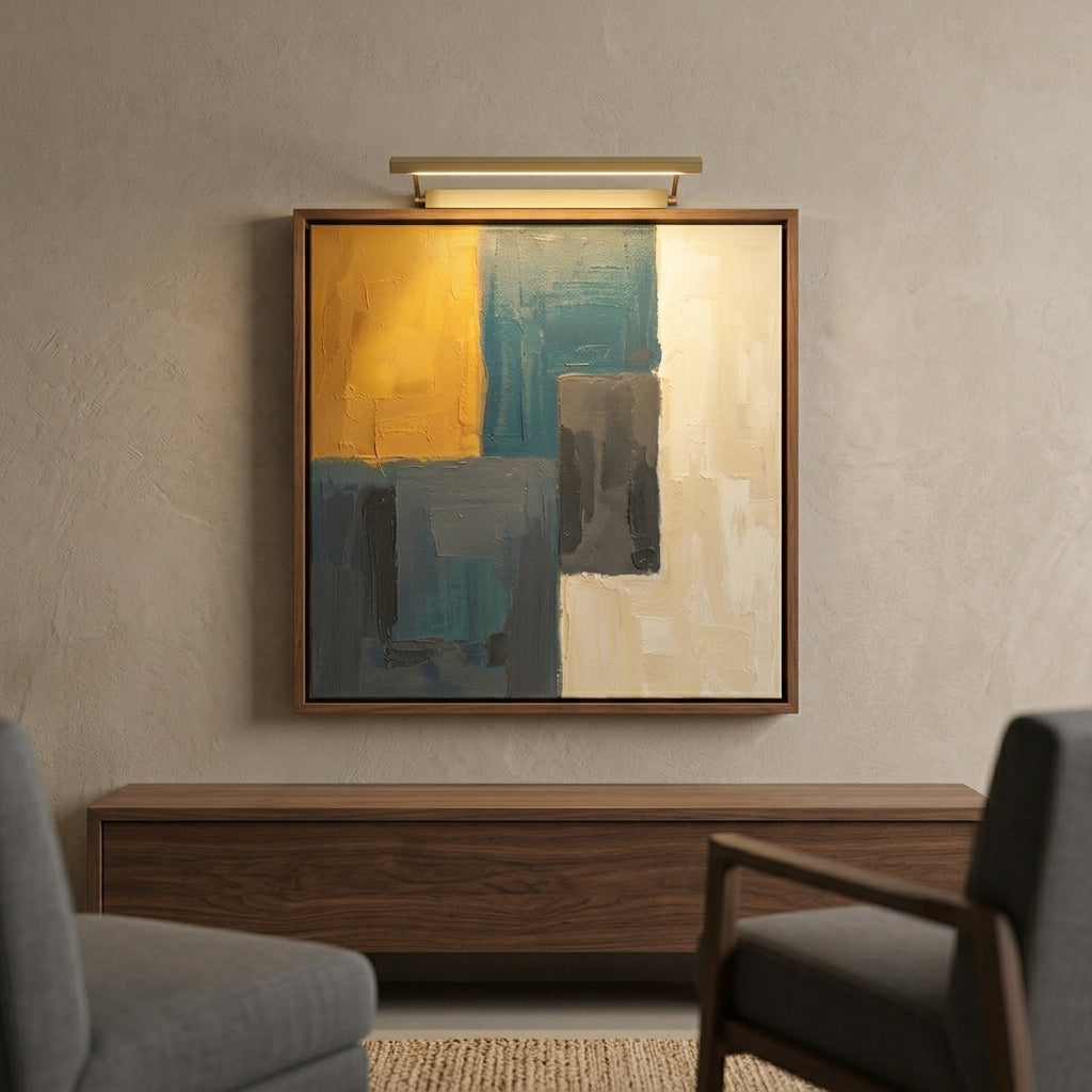 Abstract framed wall art hanging above a wooden console in a modern living room, with a wall sconce above the frame. The artwork features large blocks of mustard yellow, teal, gray, and cream.