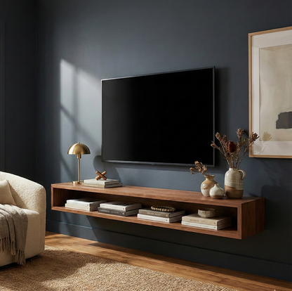 Modern living room with a television mounted on a dark wall, wooden shelf with decorative items, and a sofa.