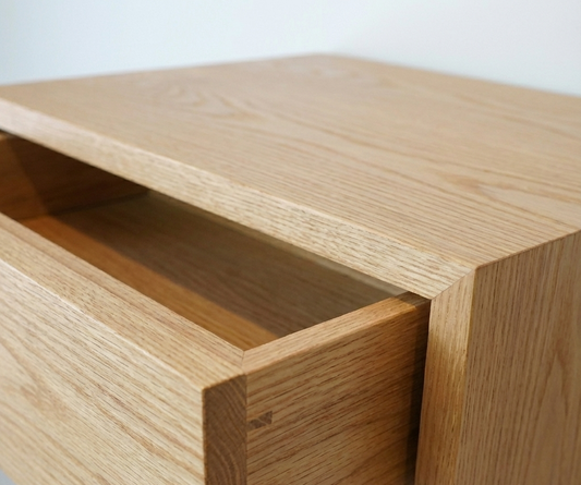 Close-up of a wooden drawer with a light finish.