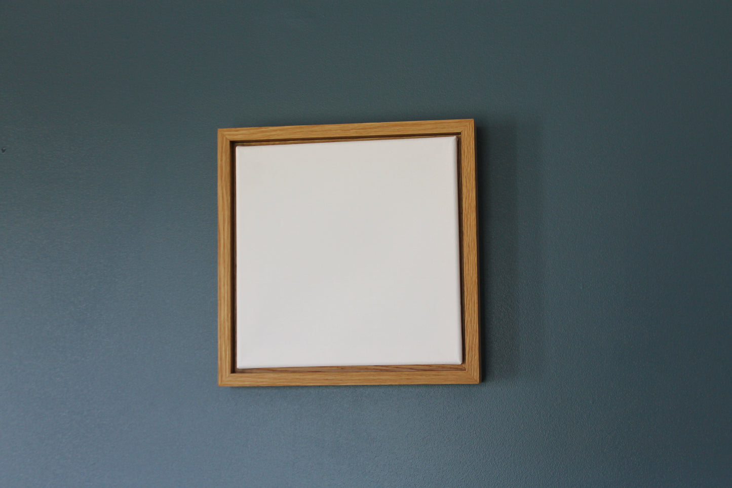 a wooden frame hanging on the wall above a mirror